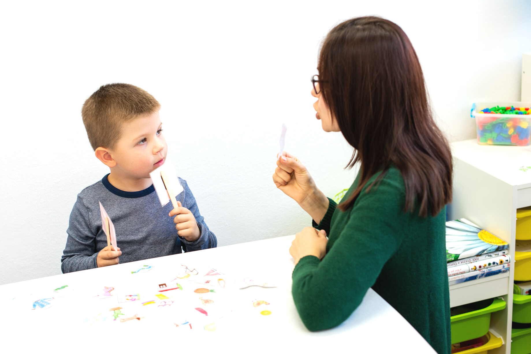 Children speech therapy concept. Preschooler practicing correct pronunciation with a female speech therapist.